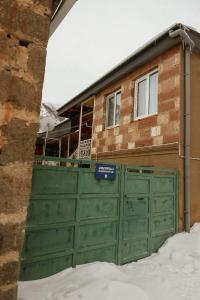 una puerta verde de garaje frente a una casa en GERGETI Arsenas Guest House, en Kazbegi
