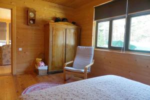 a bedroom with a bed and a chair and a window at Kadiķi in Ventspils
