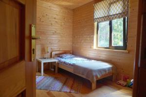 um pequeno quarto com uma cama e uma janela em Kadiķi em Ventspils