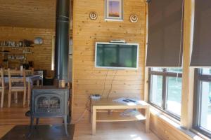 a living room with a stove and a tv at Kadiķi in Ventspils