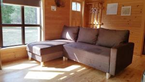 a couch sitting in a room with a window at Kadiķi in Ventspils +8 photos