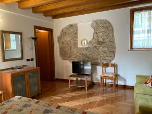 sala de estar con TV y pared de piedra. en Desenzano del Garda Mirella house, en Desenzano del Garda 9 fotos más