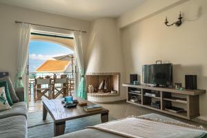 Una sala de estar con un sofá y un televisor. en Villa Millianna - Ground Floor Apt, en Cefalonia