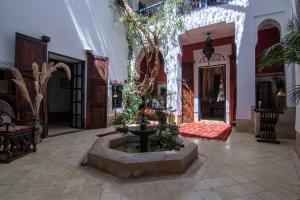 a lobby with a fountain in the middle of a room at Dar Oulhoum in Marrakesh