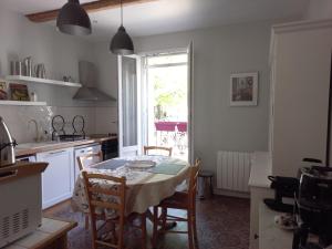 cocina con mesa, sillas y ventana en LA ROSE DES VENTS, en Le Pouget