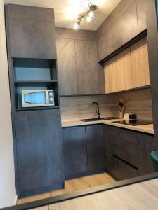 a kitchen with a sink and a microwave at Apartman ‘Marko’ in Kutina +4 photos