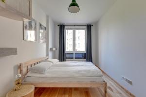 a small bedroom with a bed and a window at Staywin WILCZA apartments in Gdańsk