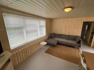 a living room with a couch and a window at Gezellige bungalow op steenworp afstand van het strand in Ouddorp