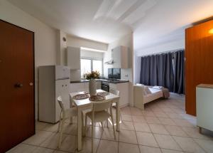 a kitchen and living room with a table and chairs at Residence Alessandra in Cesenatico