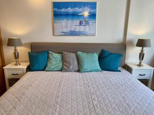 um quarto com uma cama grande e almofadas azuis em Studio Calisto em Carvoeiro