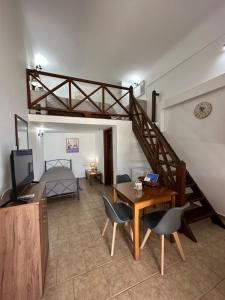 sala de estar con escalera, mesa y sillas en Ano Syros Vibes en Syros