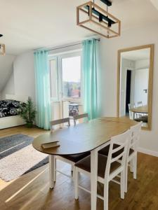 a dining room with a wooden table and chairs at Zakątek Solny in Bochnia