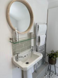 ein Bad mit einem Waschbecken und einem Spiegel in der Unterkunft Quayside Georgian Townhouse in Kings Lynn