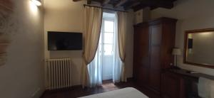 a bedroom with a bed and a window and a television at Relais Giulia in Rome