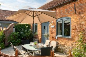 a table and chairs with an umbrella on a patio at The Stables in Tunstead