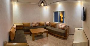 ein Wohnzimmer mit einem Sofa und einem Tisch in der Unterkunft Appartement Lilia, Mdiq - Tout confort in Mʼdik