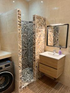 a bathroom with a sink and a washing machine at Appartement Lilia, Mdiq - Tout confort in M'diq