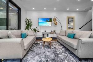 a living room with two couches and a table at Glen Oak Bungalow in Los Angeles