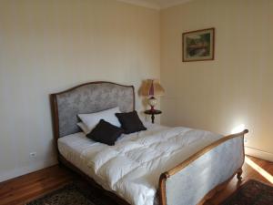 een slaapkamer met een bed met 2 kussens erop bij Villa Biscondau in Oloron-Sainte-Marie