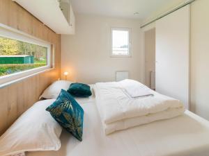 twee bedden in een kleine kamer met een raam bij Brand new spacious mobile home with private terrace, next to a babbling brook in Érezée