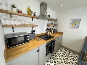 a kitchen with a counter with a microwave and a sink at Quayside Georgian Townhouse in Kings Lynn