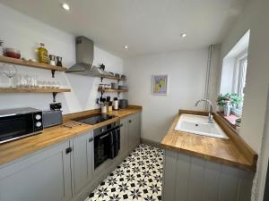 a kitchen with a sink and a microwave at Quayside Georgian Townhouse in Kings Lynn