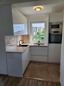 a kitchen with white cabinets and a window at Golden Sky in Cazin