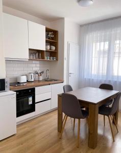 a kitchen with a table and chairs in a room at Fellas Apartments in Prizren