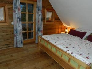 een slaapkamer met een bed in een blokhut bij Chalet Teufelsteinblick in Fischbach