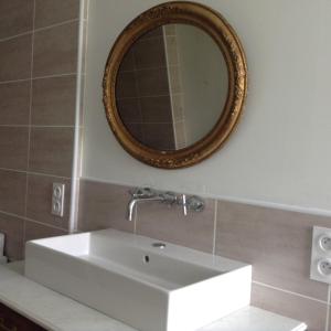 een badkamer met een witte wastafel en een spiegel bij Villa Biscondau in Oloron-Sainte-Marie
