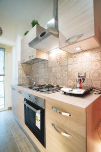 a kitchen with wooden cabinets and a stove top oven at Verrazzano 37 Guest House in Rome