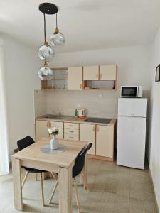 a kitchen with a table and a white refrigerator at Two person apartment in Nin