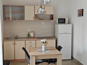 a small kitchen with a table and a refrigerator at Two person apartment in Nin