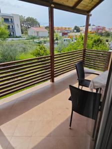 a balcony with two chairs and a table and a view at Two person apartment in Nin