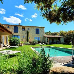 an external view of a villa with a swimming pool at Superb air-conditioned house with heated pool in Gordes - by feelluxuryholydays in Gordes
