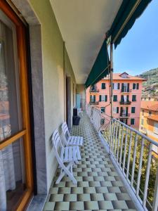 zwei weiße Stühle auf dem Balkon eines Gebäudes in der Unterkunft La Casa di Barbara By PortofinoVacanze in Santa Margherita Ligure