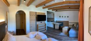 Habitación con cama y sala de estar con cocina. en Garni & Residence Sonngart, en Lagundo