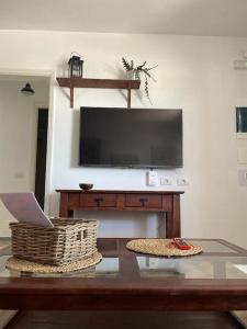 salon z telewizorem i stołem z laptopem w obiekcie Lanzarote Sea, acogedora vivienda w Puerto del Carmen