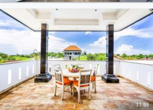 a dining room with a table and chairs on a balcony at Zsa Zsa Bali Five-Bedroom Villa with Private Pool Pool in Ungasan