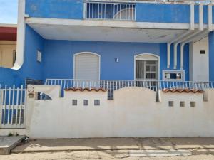 a blue house with a white wall at Casa Azzurra in Villaggio Azzurro