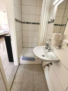 ein Badezimmer mit einem Waschbecken und einer Badewanne in der Unterkunft Boardinghouse Wendelstein in Wendelstein
