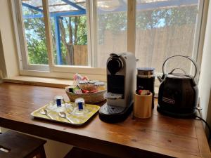 a counter top with a coffee maker and a tea kettle at יחידת אירוח נעם in Netiv HaLamed He