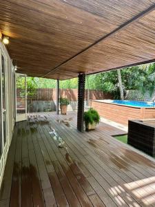 eine Terrasse mit einer Holzterrasse und einem Pool in der Unterkunft villa chez Lisa in La Gaulette