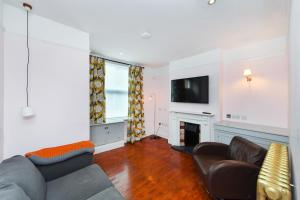 a living room with a couch and a tv at Highfield Grove - Beautifully Bright 2BR, West Bridgford in Nottingham