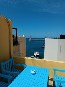 a blue table and chairs on a balcony with the ocean at Imeros in Chania Town