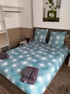 a bedroom with a blue bed with two towels on it at Au Vélo Fleuri in Bracieux