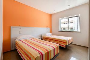 ラゴスにあるDona Ana Beach Apartment with amazing sea viewsのオレンジ色の壁の客室内のベッド2台