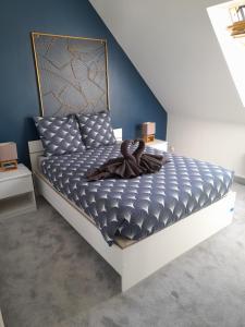 a bedroom with a bed with a blue wall at Appartements Lannion proche centre, Côtes de Granit Rose in Lannion