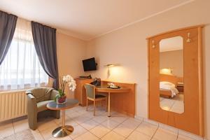 a hotel room with a table and a mirror at Hotel Re'ser Stuff in Roeser