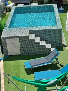 een uitzicht over het zwembad met 2 ligstoelen bij O Quintal Guesthouse in Carvoeiro